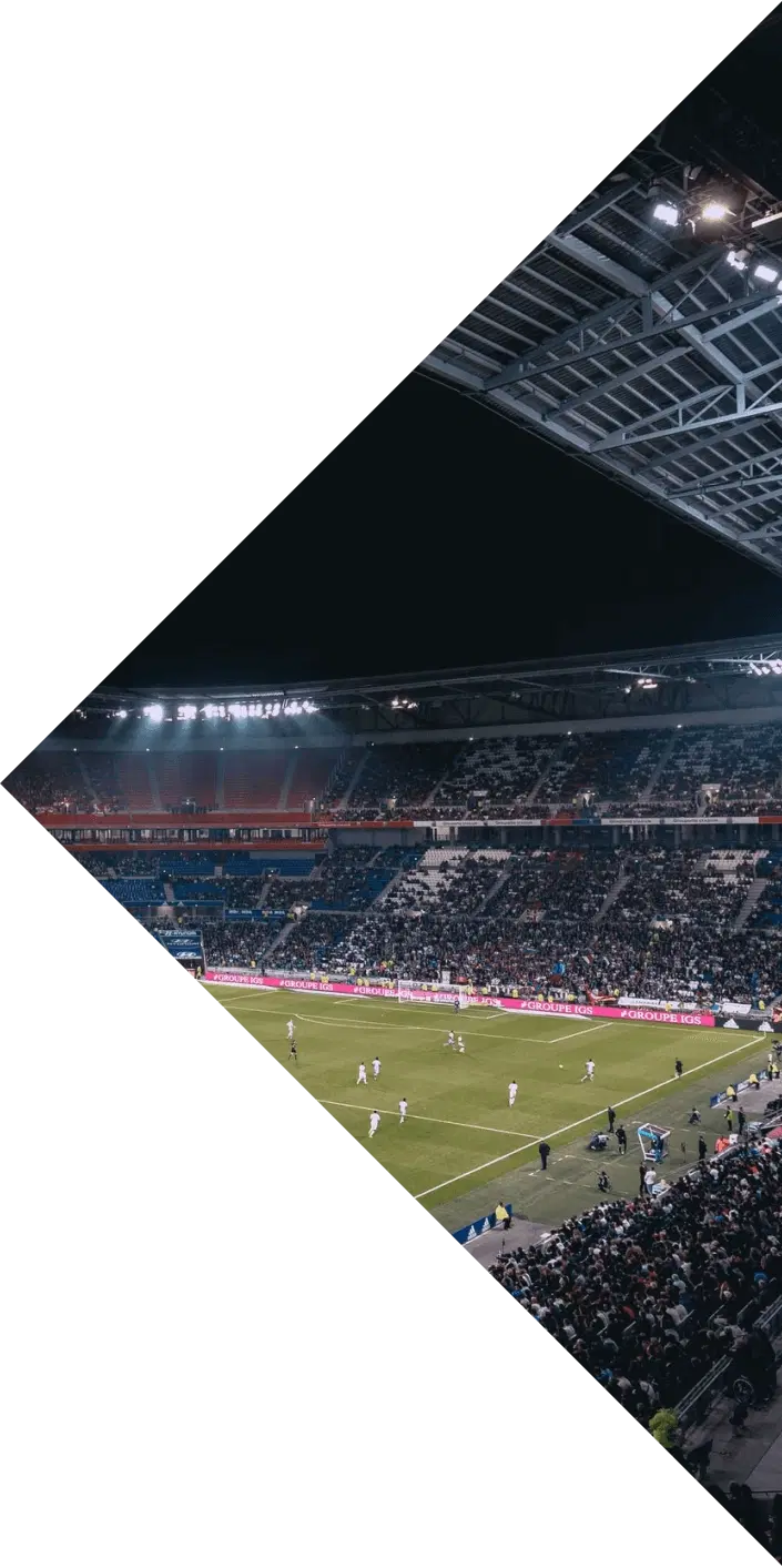 Floodlit football stadium full of fans during a night match